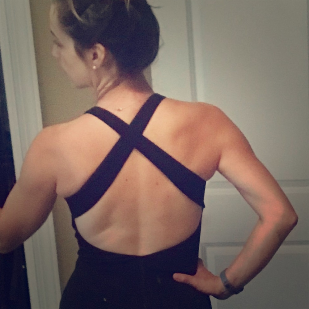 Floor-length black, open-back dress.